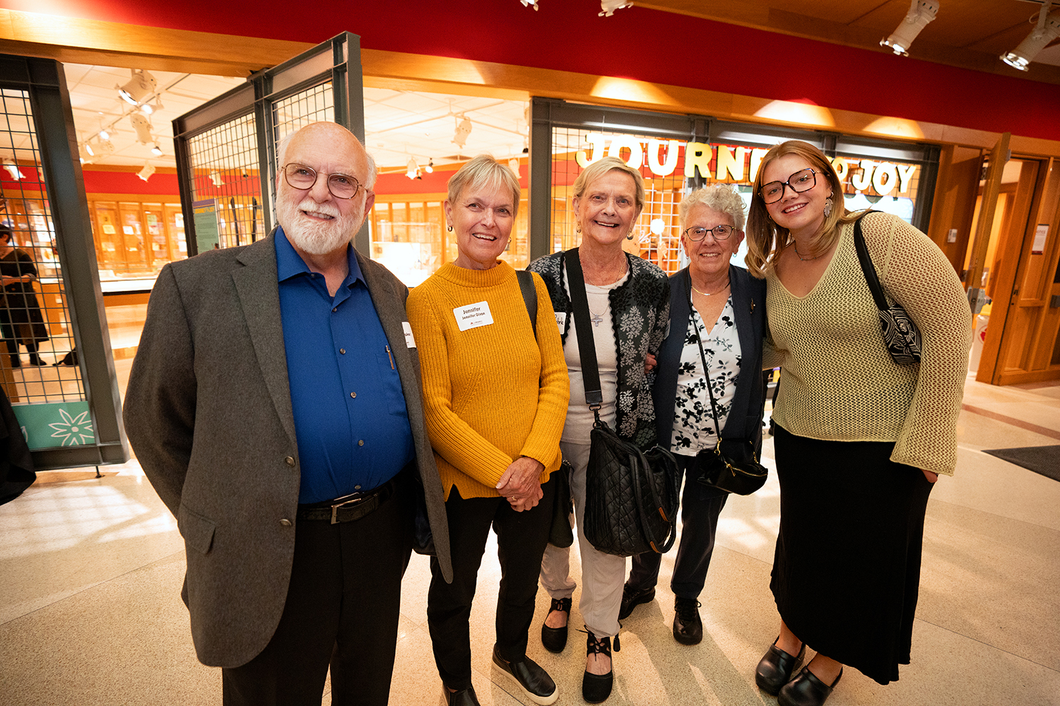 Five people stand side by side and smile at the camera in the atrium of Elmer L. Andersen Library for the Kerlan Award ceremony