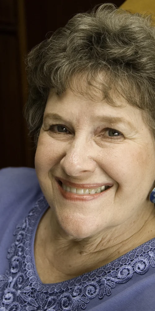 Headshot of older woman with short curly hair